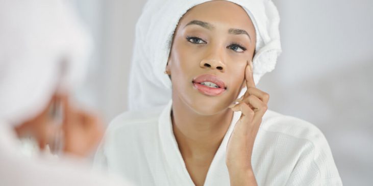 Woman looking at skin in mirror