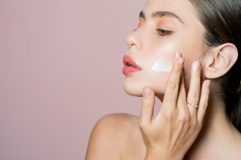 Woman applying face moisturizers