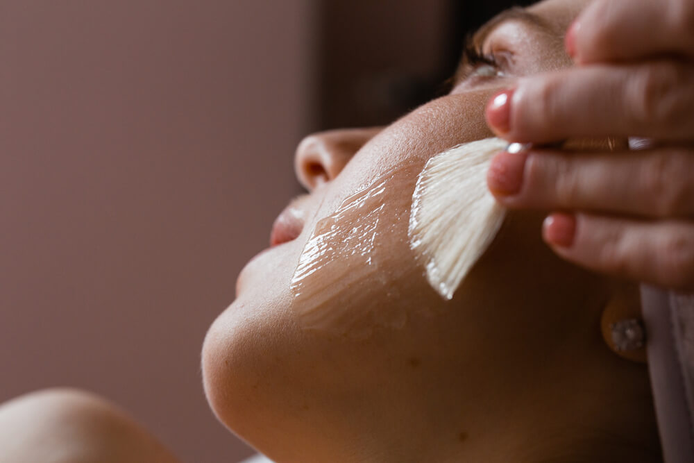 Woman applying peeling gel to face