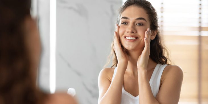 Woman looking at sun damage in skin