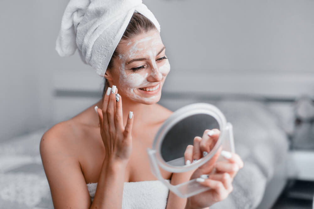 Woman applying hydrating face mask