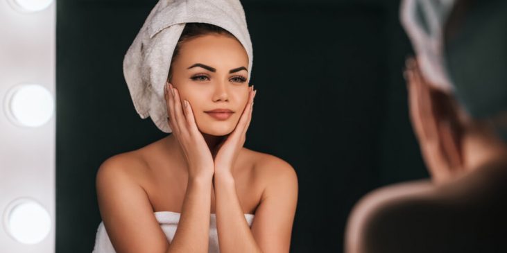 Woman looking at skin in mirror