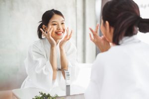 Woman using self love skincare products