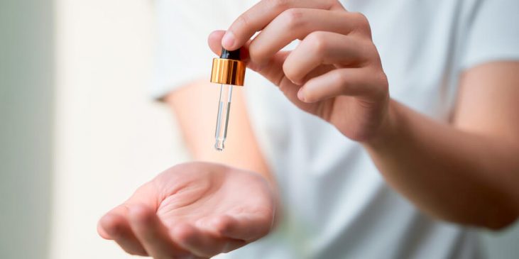 Woman applying serum to hand