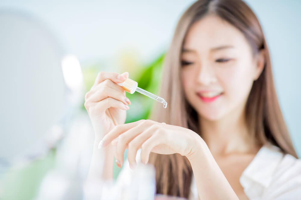 Woman applying serum to hand