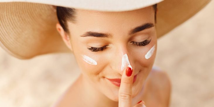 Woman using skin cream in summer