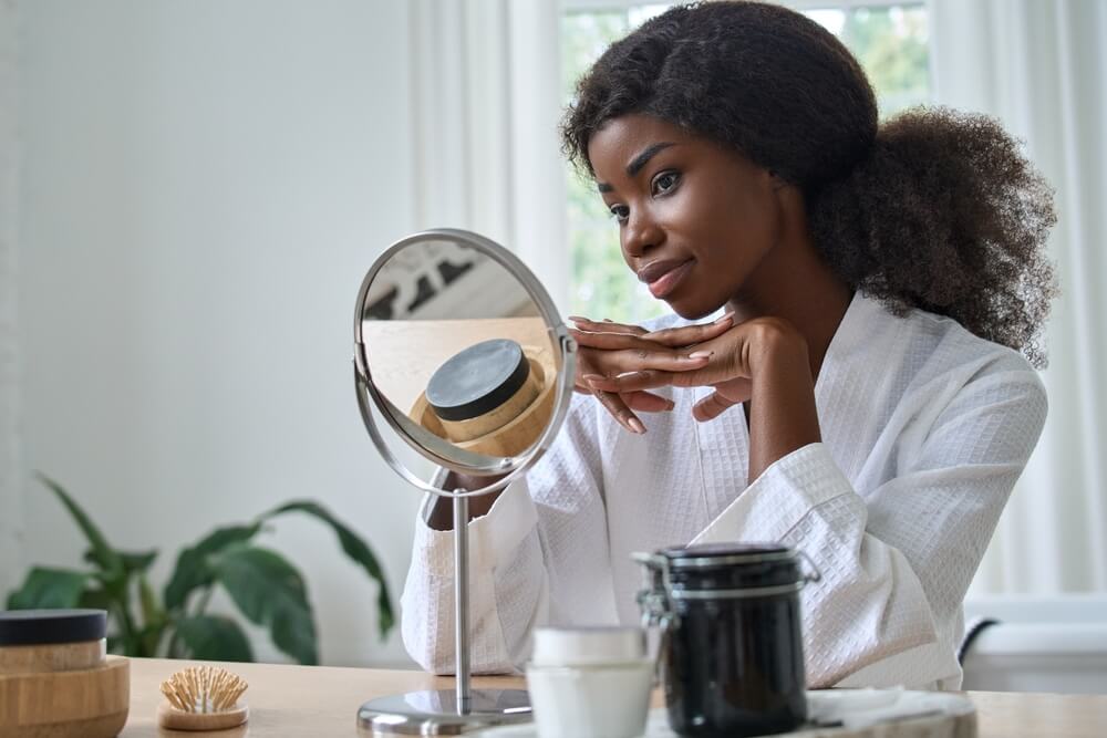 Woman looking at skin in mirror