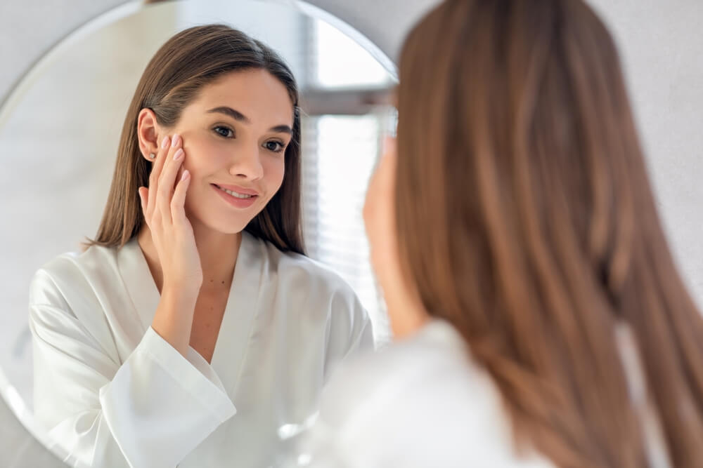 Woman looking at skin in mirror