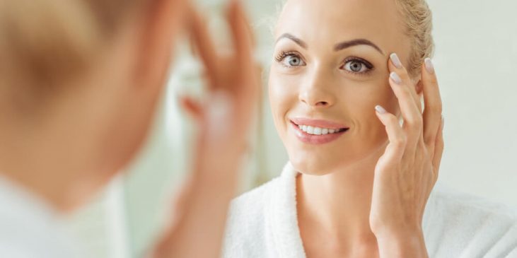 Woman looking at skin in mirror