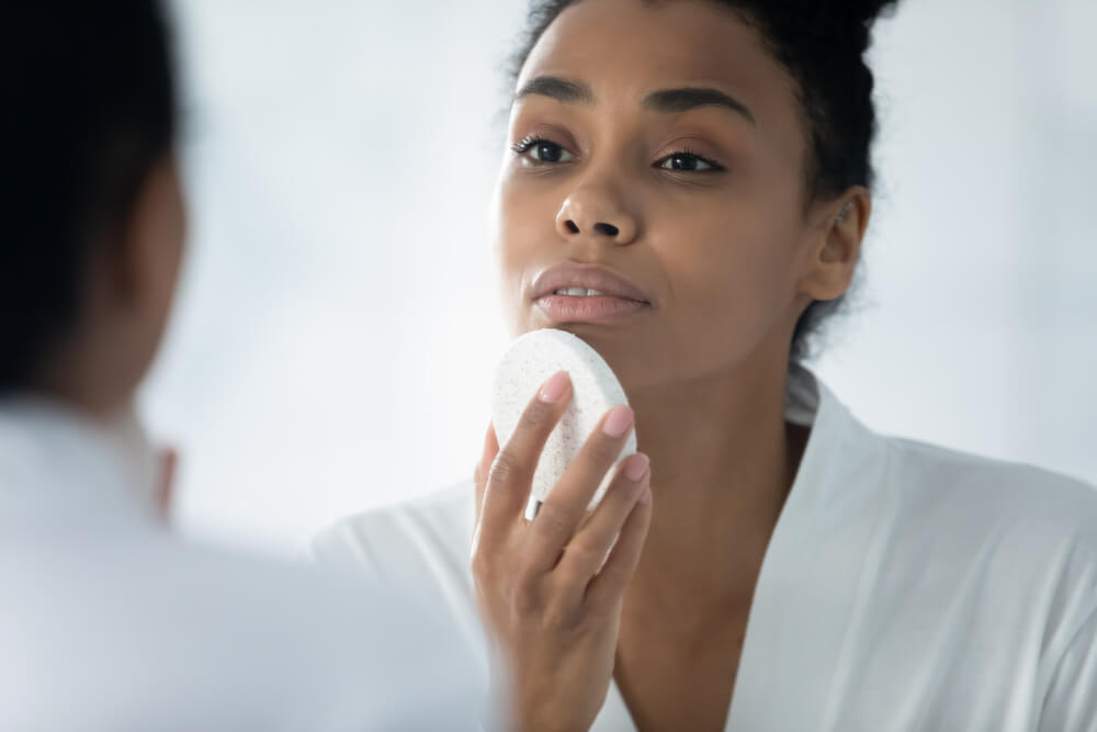 woman exfoliating face